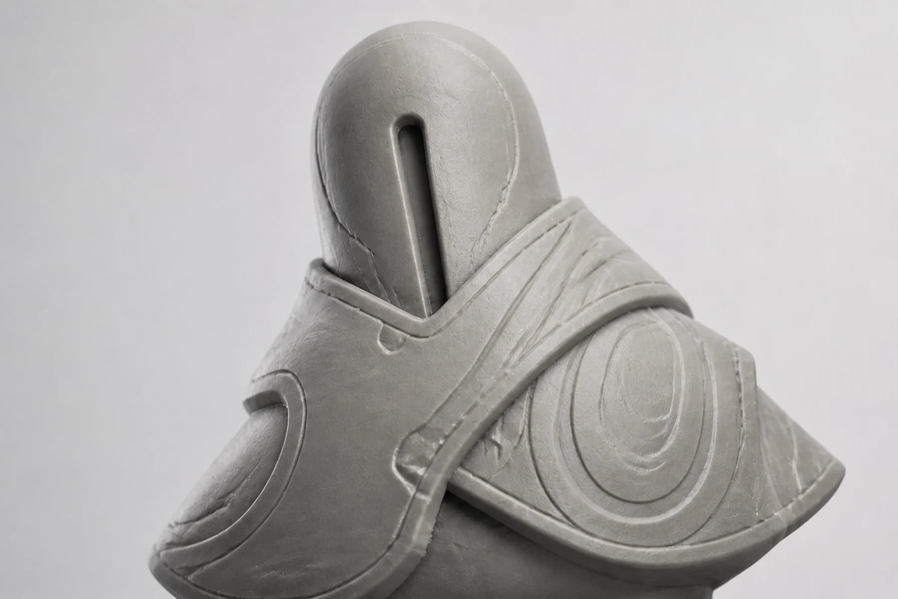 A close digital sculpt view showing the character's recessed face slit and layered mantle details.